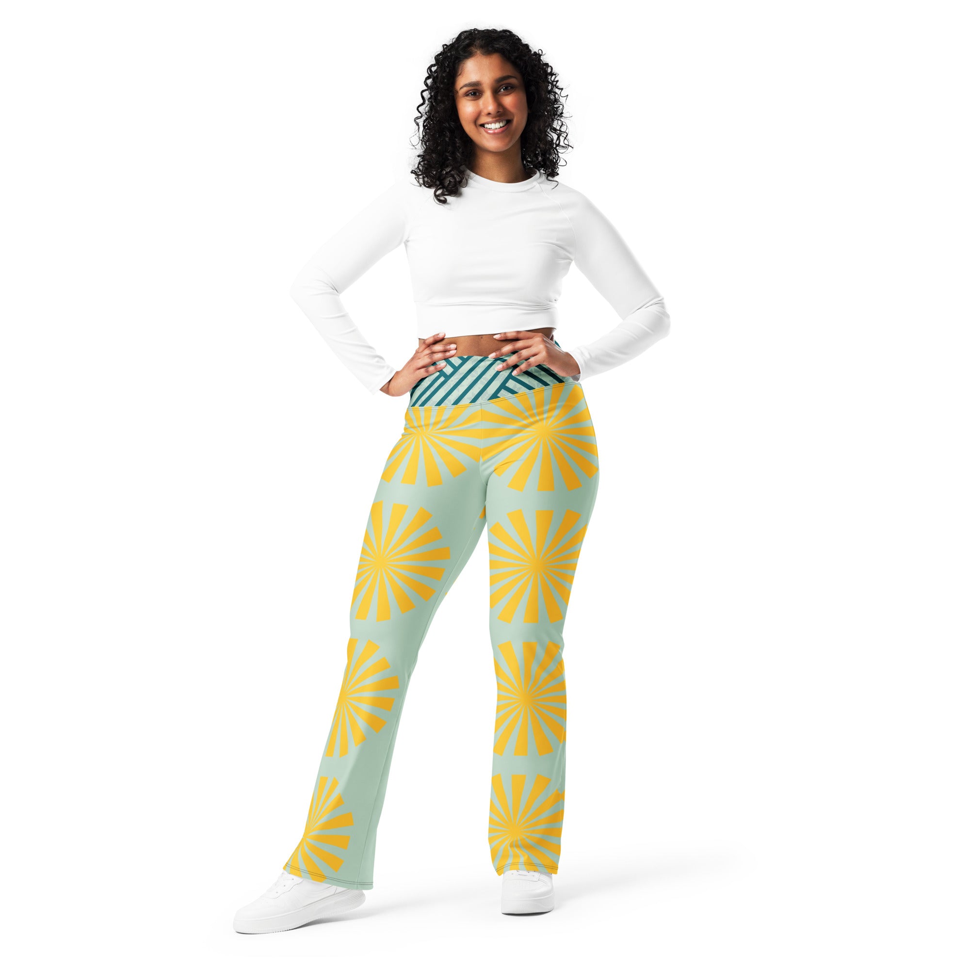 Legging évasé bleu clair à motif soleil jaune, coupe évasée et taille rayée vert foncé.