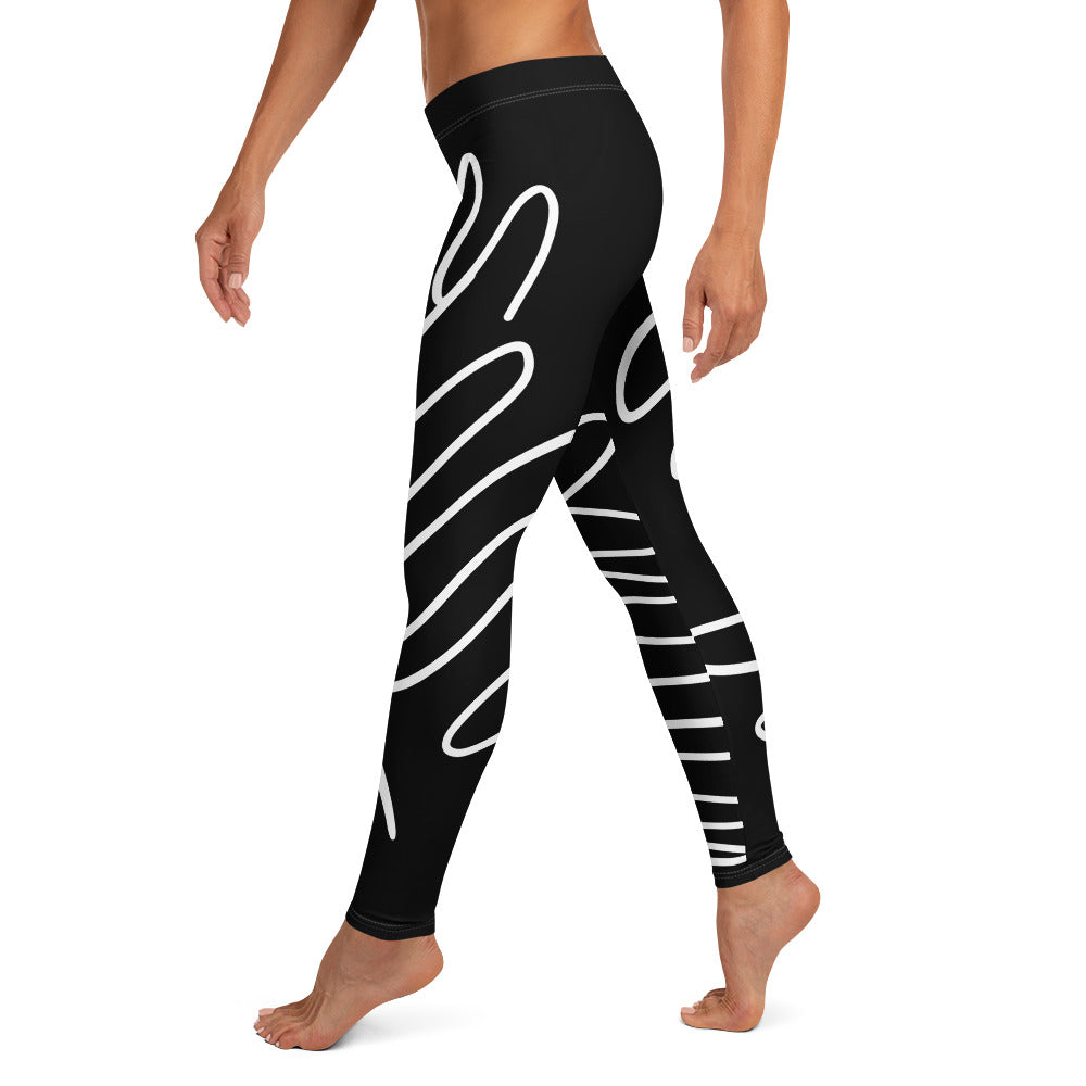 Legging noir à taille haute et lignes blanches abstraites sur les jambes.