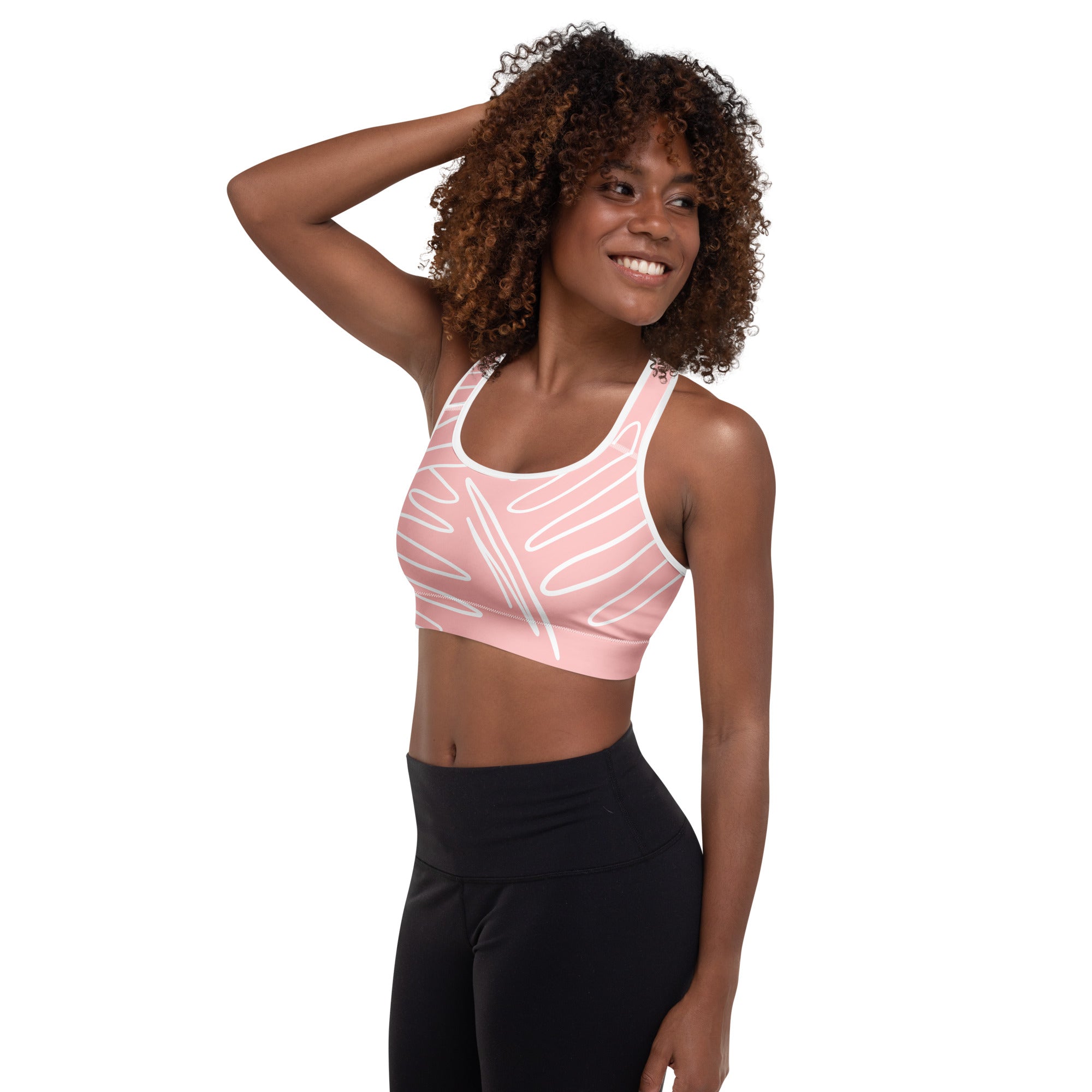 Brassière de sport rose rembourrée, bretelles croisées, motif blanc abstrait et logo discret