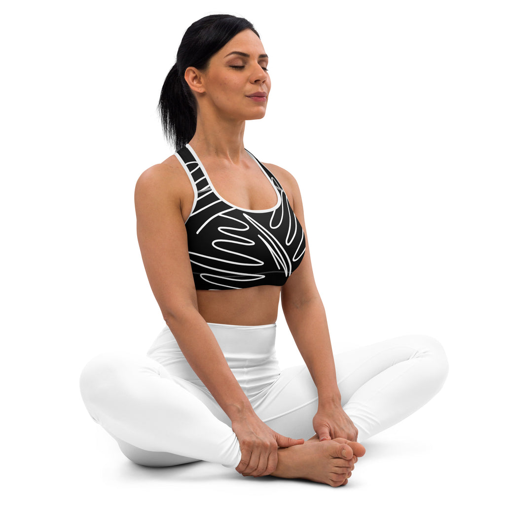 Brassière de sport rembourrée noire à motifs blancs sur le devant, bretelles contrastées.