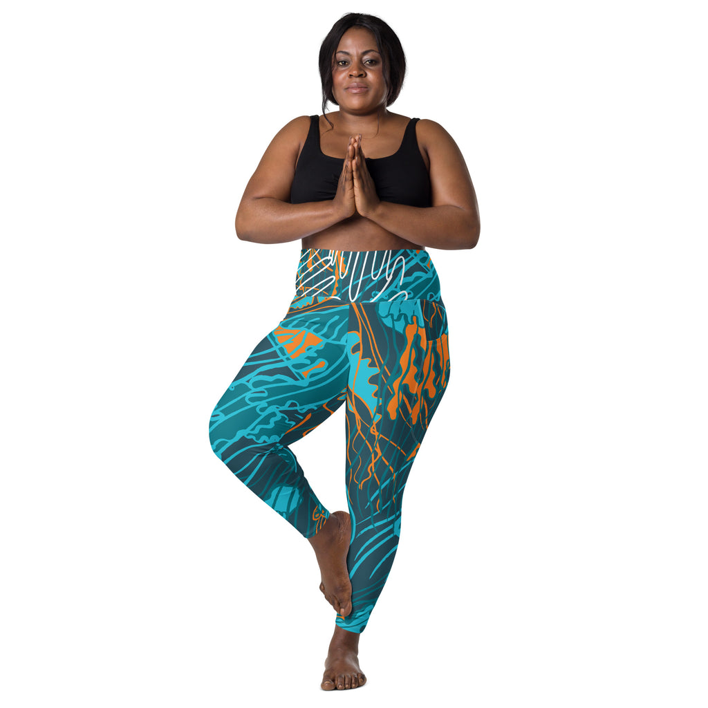 Legging taille haute imprimé bleu turquoise à motifs orange, posture à genou fléchi.