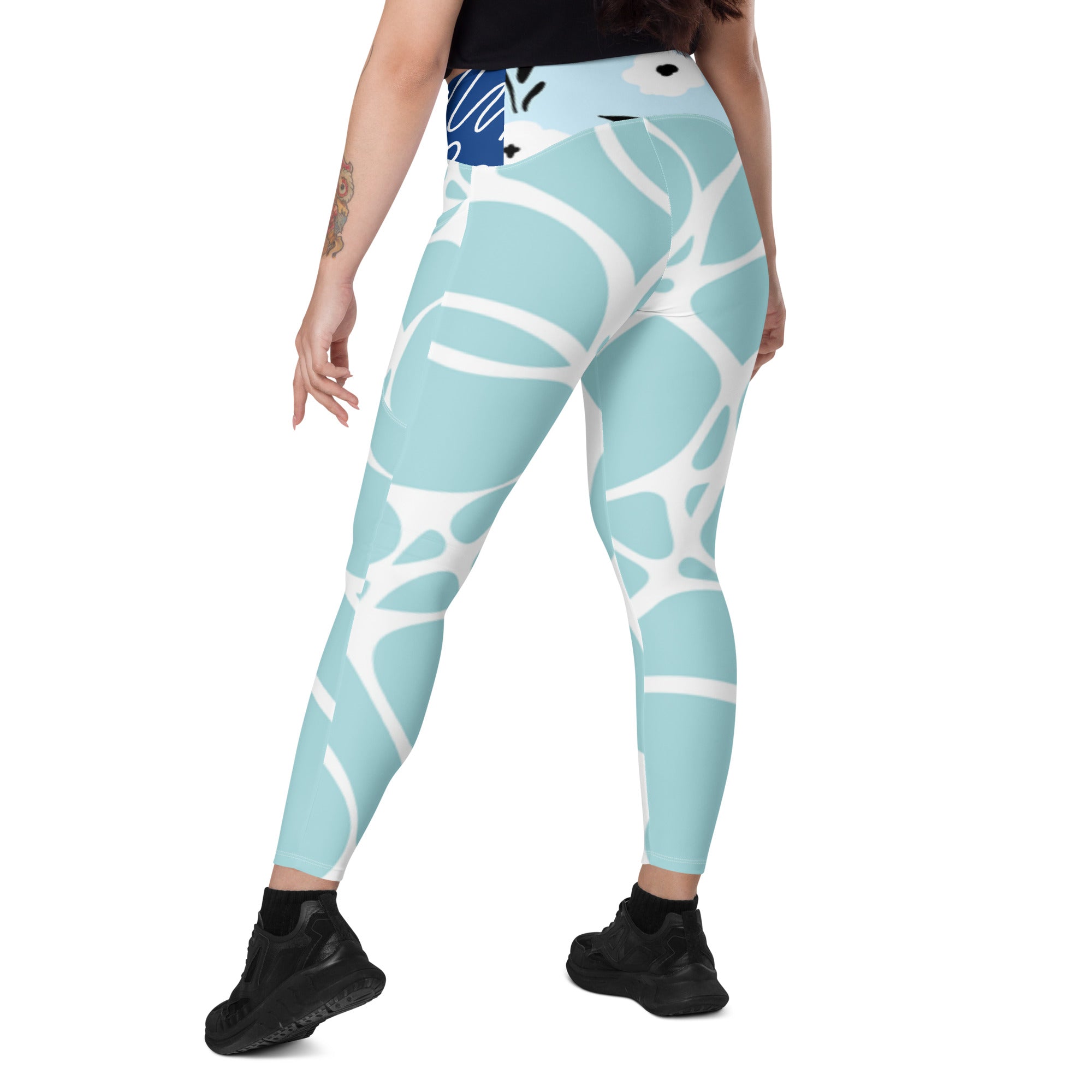 Leggings turquoise à motif abstrait blanc, taille haute, coupe près du corps.