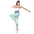 Leggings aqua motif feuilles blanches, taille haute, jambe fuselée près du corps.