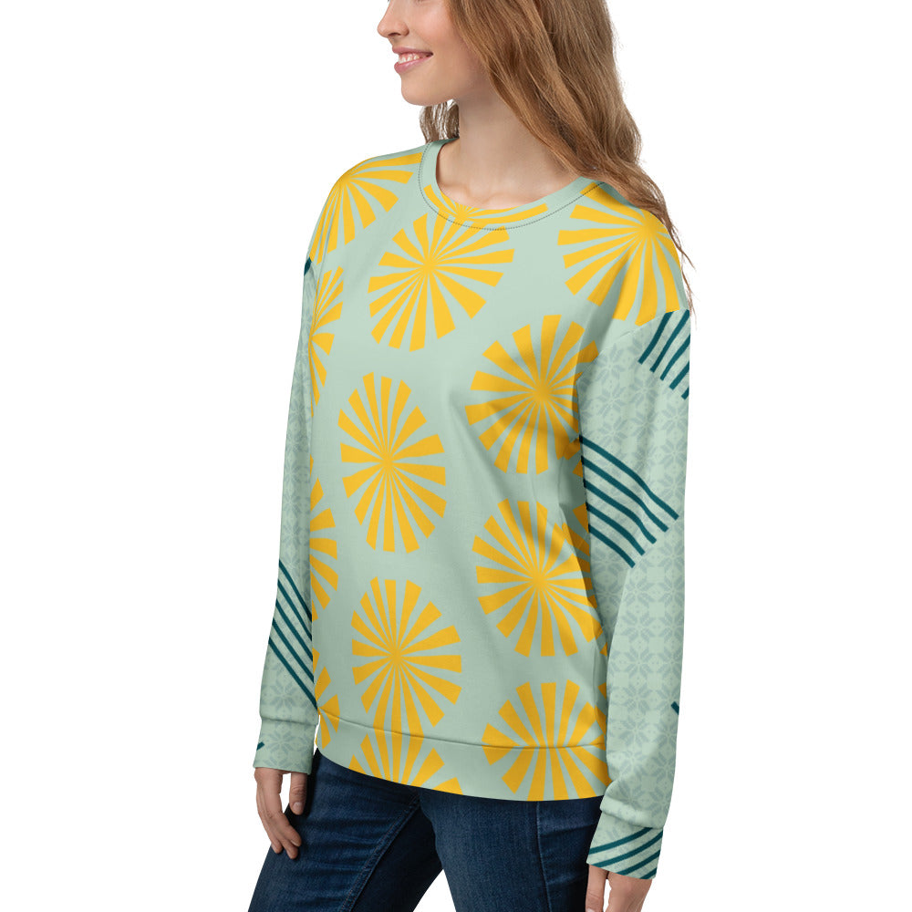 Sweat-shirt bleu clair à motifs fleurs jaunes, col rond côtelé et empiècements rayés sur les manches.