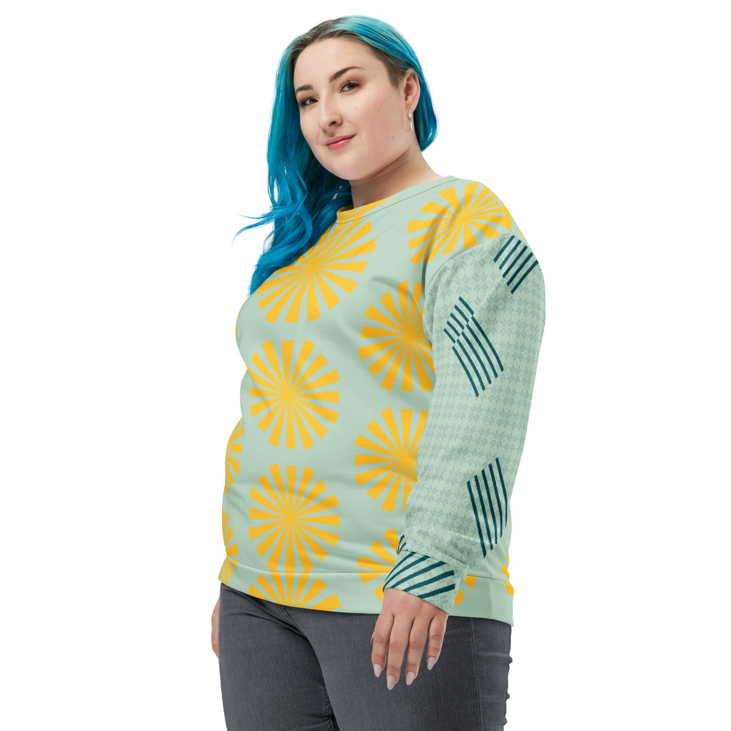 Sweat-shirt bleu clair à motifs fleurs jaunes, manches longues avec rayures vert foncé et col rond.