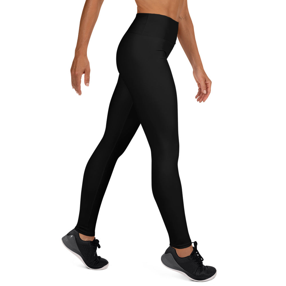 Legging noir taille haute, tissu lisse, près du corps jusqu’aux chevilles.