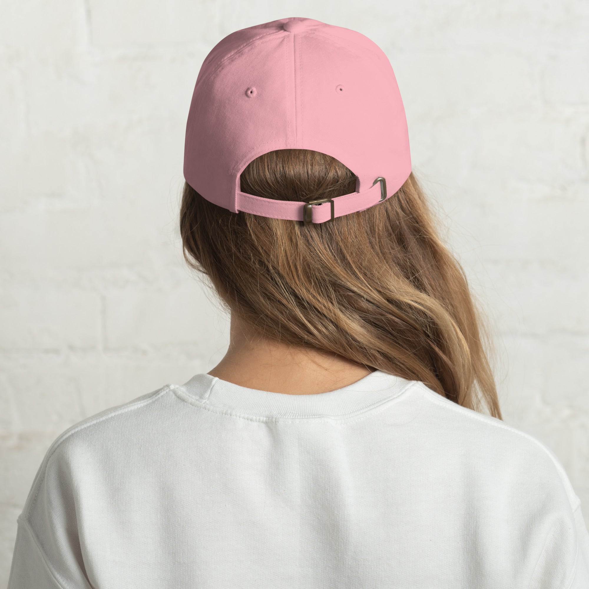 Casquette rose vue de dos, sangle réglable noire et visière orientée vers l’avant.