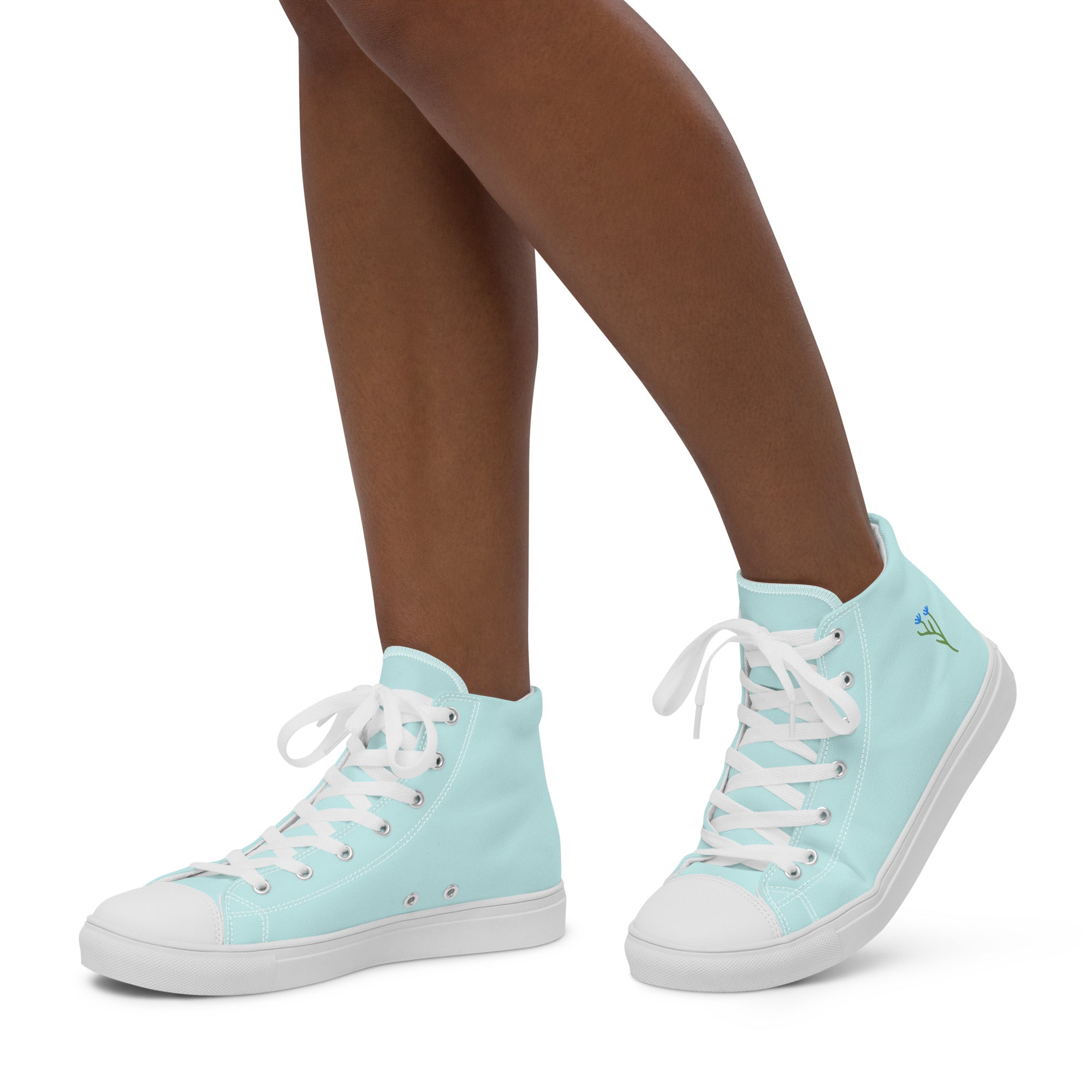 Baskets hautes en toile bleu clair portées, lacets blancs, semelle blanche, sur pied.